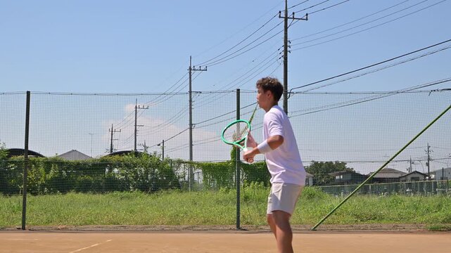 テニスコートでテニスを楽しむ学生選手