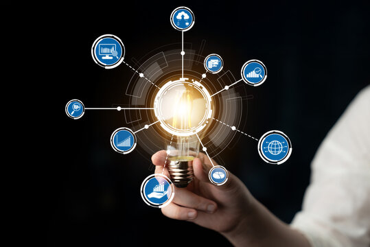 A captivating image of a hand holding a light bulb, symbolizing innovation and creativity, surrounded by digital icons representing technology and growth in a dark setting. Crux