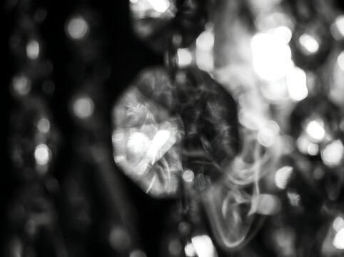 An abstract black and white depiction of a blurred human figure surrounded by bright lights evoking a sense of mystery and intrigue