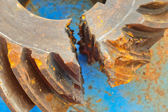 Spiral bevel gear of engine transmission in damaged and cracked condition due to heavy duty used. Industrial equipment object, close-up with selecive focus.
