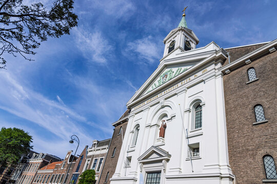 Haarlem, Netherlands: Low angle view of the impressive white neoclassical facade of the Groenmarktkerk (Antonius van Paduakerk) against a blue sky in summer.