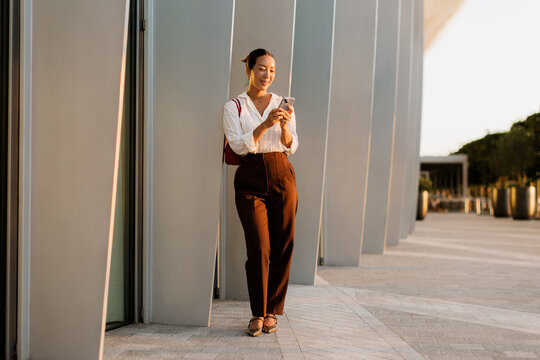 Korean woman enjoying a sunny moment while checking her phone