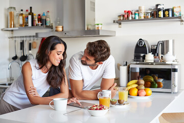 Happy, couple and discussion in kitchen with tablet, connection and opinion for online news update....