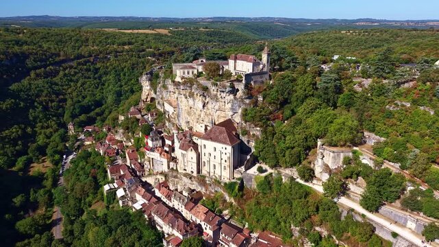 Drone flies away from the cliff revealing Rocamadour village and valley below
