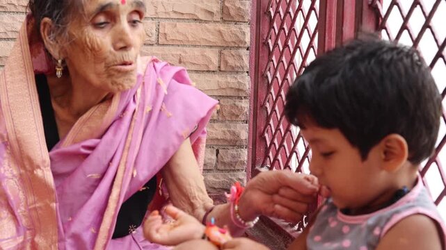 Loving elderly Indian grandmother sharing a tender moment with her young grandchild at home, showing family affection, care, and strong intergenerational bonding.