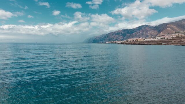 Aerial view of a coastal city and the ocean, Atlantic Ocean, Tenerife: view of the town and the Los Gigantes cliffs and Masca Mountains.
