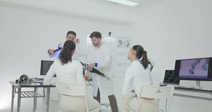 Engineers presenting and testing robotic arm at technical drawing board in white robotics lab