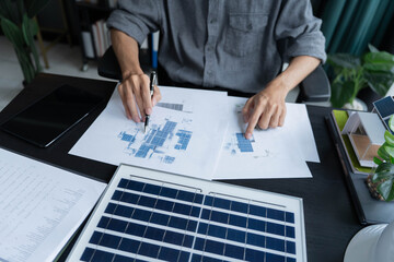 Electrical engineer working on solar panel blueprint sustainable energy © Wanda