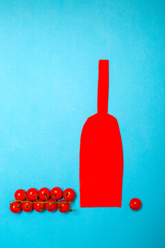 Ripe red tomatoes with a red bottle cut out of cardboard