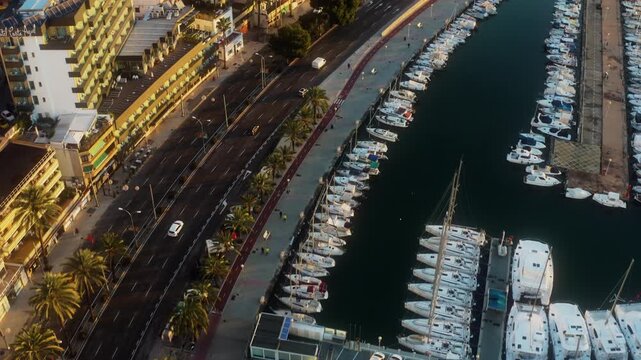 Hovering drone frames Palma marina docks beside a waterfront boulevard in Spain