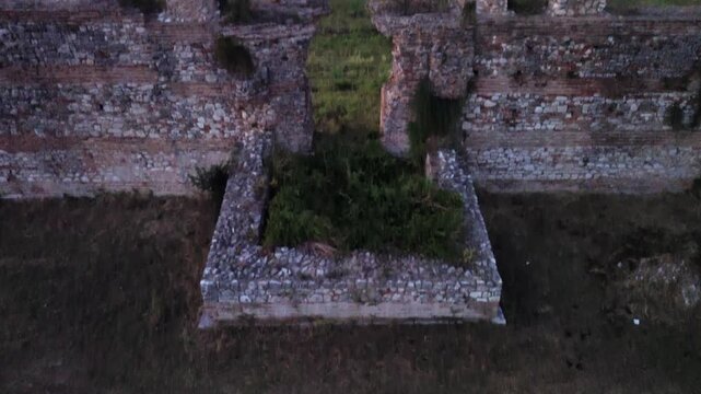 Lateral horizontal camera movement as a drone flies sideways revealing the historic brick walls and stone ruins of ancient Nikopolis.
