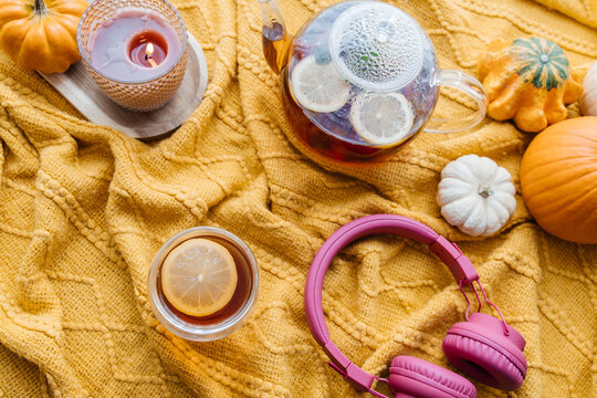 Autumn tea time with headphones and pumpkins enjoying hygge