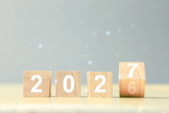 Wooden number blocks showing 2026 and 2027 transition with glowing lights, symbolizing New Year, future goals, business planning, growth, change, progress, success, and fresh beginnings.