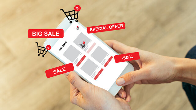 Hands holding smartphone showing online shopping screen with big sale and special offer messages