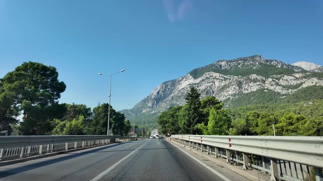 Driving along a scenic mountain road surrounded by forest, slow motion