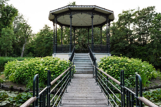 Ornate black gazebo in a lush green park