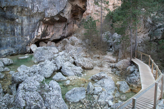 Wooden walkway crossing rocky riverbed in canyon