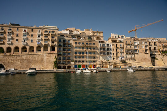 Historic buildings along a sunny European harbor