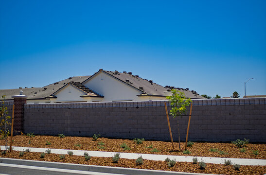 New house under construction stands behind brick boundary wall
