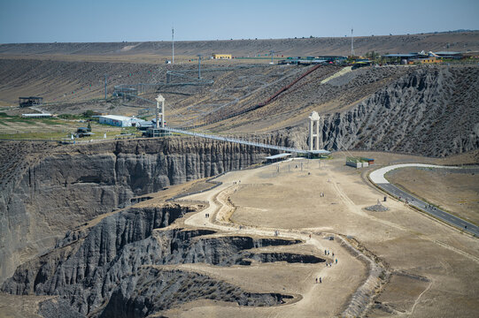 Aerial Close-up View of Duku Glass Bridge at Dushanzi Grand Canyon in Xinjiang: Suspension Glass Bridge, Cliff Walkway, Mudstone Canyon and Geological Formations
