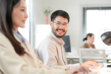 Obraz premium He tilts his head and answers her with a wide grin, in a daylit creative studio, an Asian architecture and design team collaborating on an environmental project.
