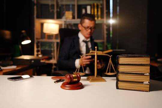 Justice and wooden gavel on desk with blurred lawyer