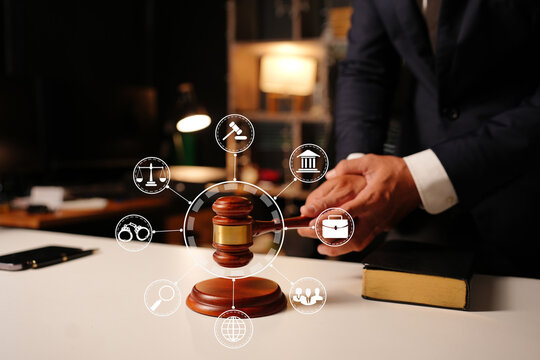 Lawyer working with law book and digital legal tech icons in office