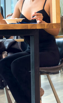 Woman sits at wooden table in restaurant
