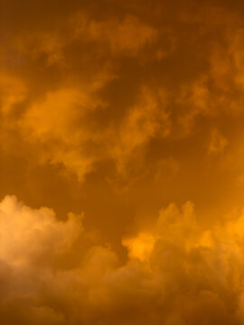 Golden clouds swirl in dramatic, warm-toned sky
