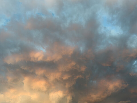 Dramatic clouds paint the sky in orange and gray