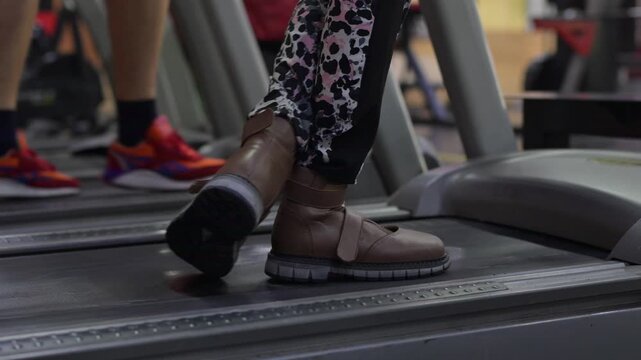 A woman with cerebral palsy walks on a treadmill. 