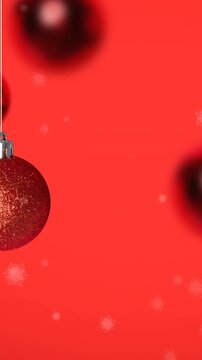 Animation of snow falling over christmas bauble decorations on red background