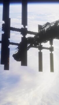 A large space station hovers in low Earth orbit, showcasing its solar panels and structure. Below, a view of Earth reveals fluffy clouds against the dark expanse of space.