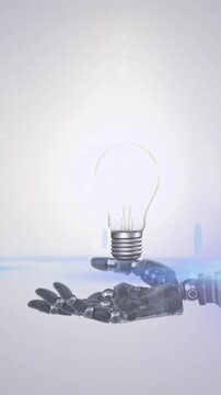 Animation of illuminated light bulb over hand of robot arm, with moving light on grey background