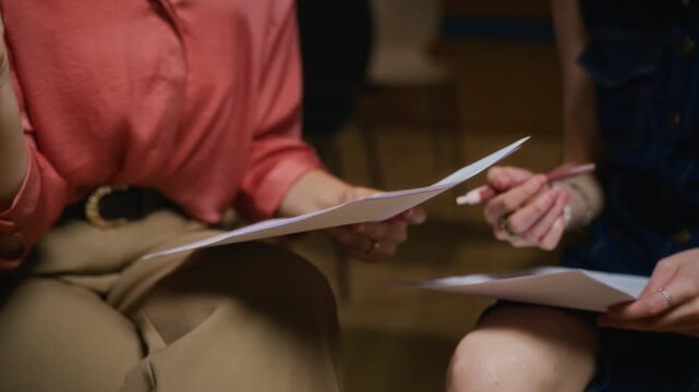 Caucasian young adult actresses rehearsing script together during theater class with tilt up motion. Ideal for drama education campaigns and acting workshop promotions