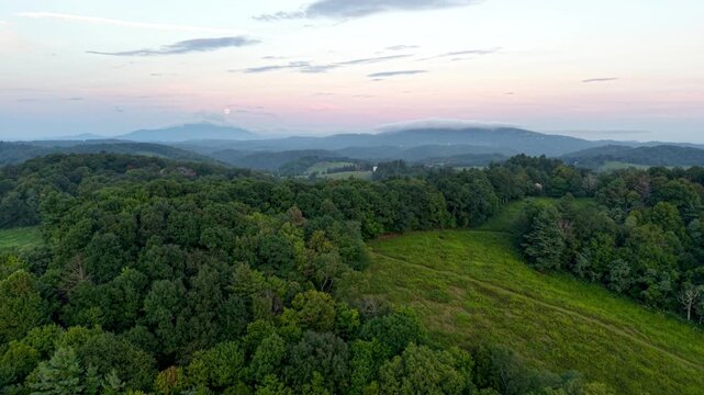 aerial push in toward grandfather mountain in the distance at sunrise near boone nc, north carolina