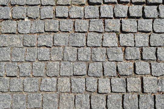 Weathered gray stone pavers in regular pattern, textured pavement background