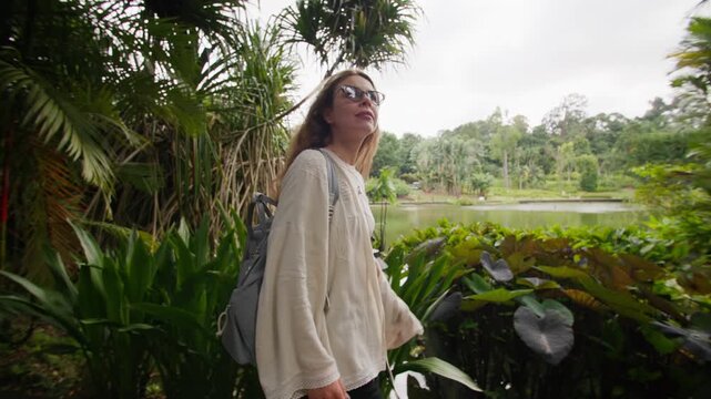 Tourist enjoying tropical nature in Singapore Botanic Gardens surrounded by lush exotic vegetation and tranquil landscapes during travel in Asia
