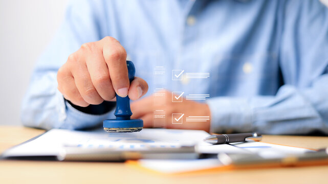 Businessman stamping rubber stamp on paper document with virtual check mark icon list, official approval process, contract certification.