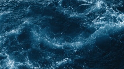 Fototapeta premium A deep blue ocean stretching across the frame with subtle foam swirls highlighting the waters texture in bright daylight.