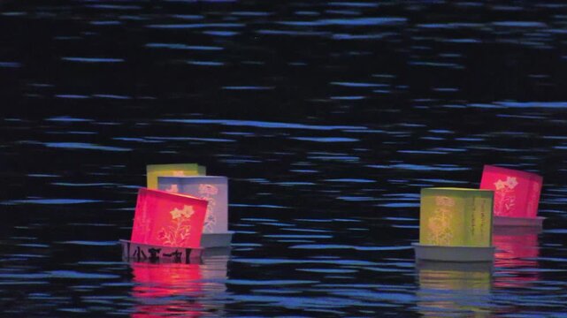 幻想的な夜の水面を流れる日本の伝統行事 灯籠流しの風景