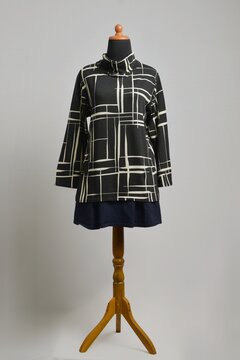 Black turtleneck sweater with abstract line pattern with navy skirt on mannequin