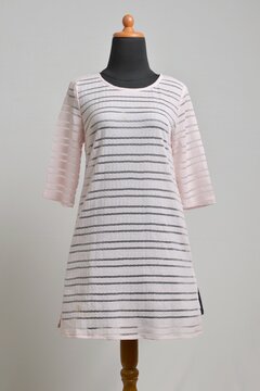 Soft pink stripes sheer sweater dress on a mannequin display