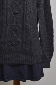 Black cable knit turtleneck sweater in details displayed on a dress form