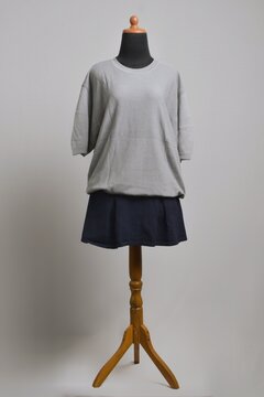 Oversize gray t-shirt with navy mini skirt on a mannequin display