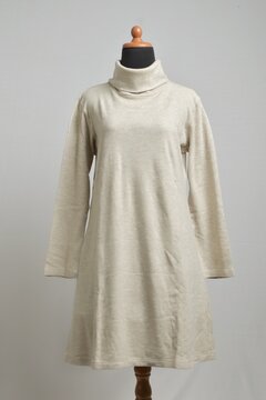 Beige turtleneck sweater dress with long sleeves on mannequin display