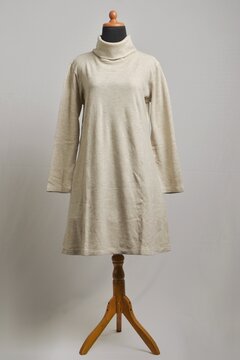 Beige turtleneck sweater dress with long sleeves on mannequin display