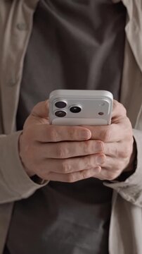 Person using smartphone with both hands in vertical close up