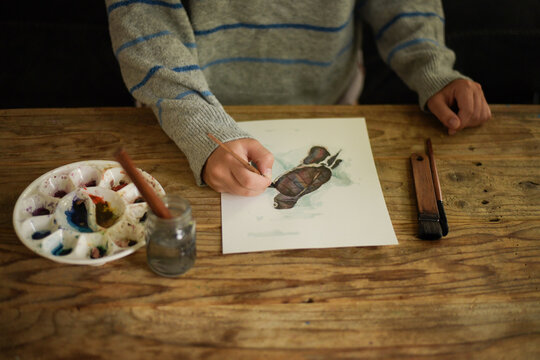 Artist painting a sea turtle illustration with watercolor paints