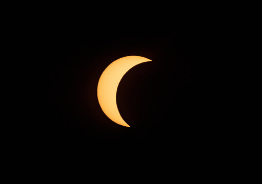Crescent sun during a partial solar eclipse against a black sky